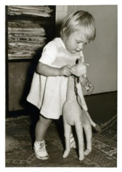 Iris als Kleinkind beim Puppenspiel